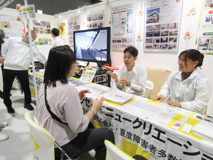 椅子を円形に並べて手話教室を行う社員と中学生