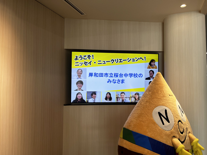 会社エントランスで社員から案内を受ける中学生